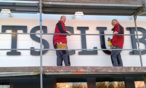 Monteure von Delta Werbetechnik montieren Buchstaben aus Dibond an einer Fassade