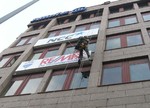 Fassadenkletterer montieren Leuchkästen an einem Bürogebäude